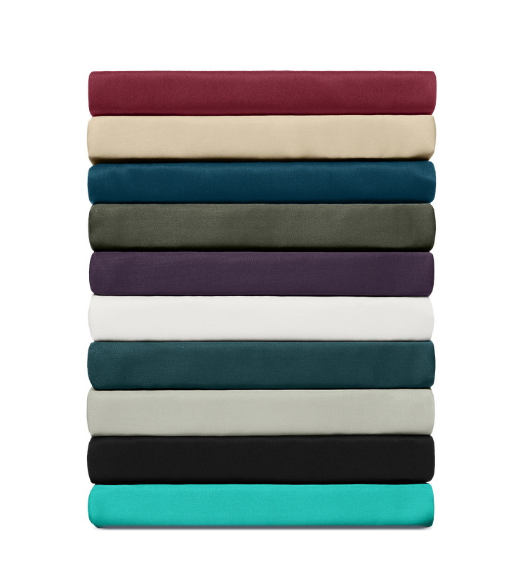Pile de draps-housses en bambou de 12 couleurs, soigneusement pliés sur fond transparent.